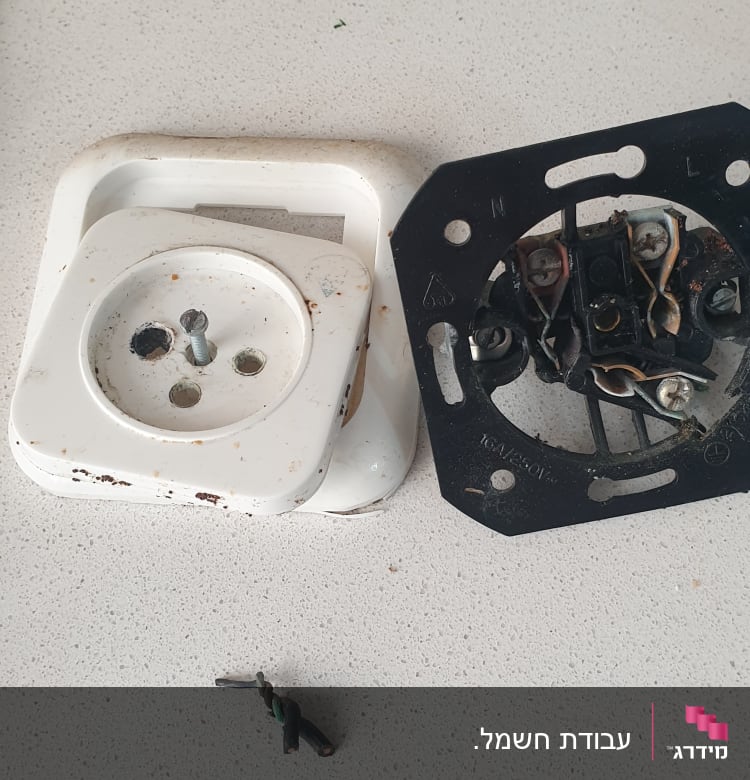 שקע חשמלי מפורק עם חוטי חשמל חשופים